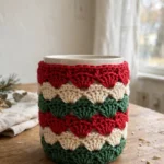 Christmas-colored crocheted mug cover in red, green and cream